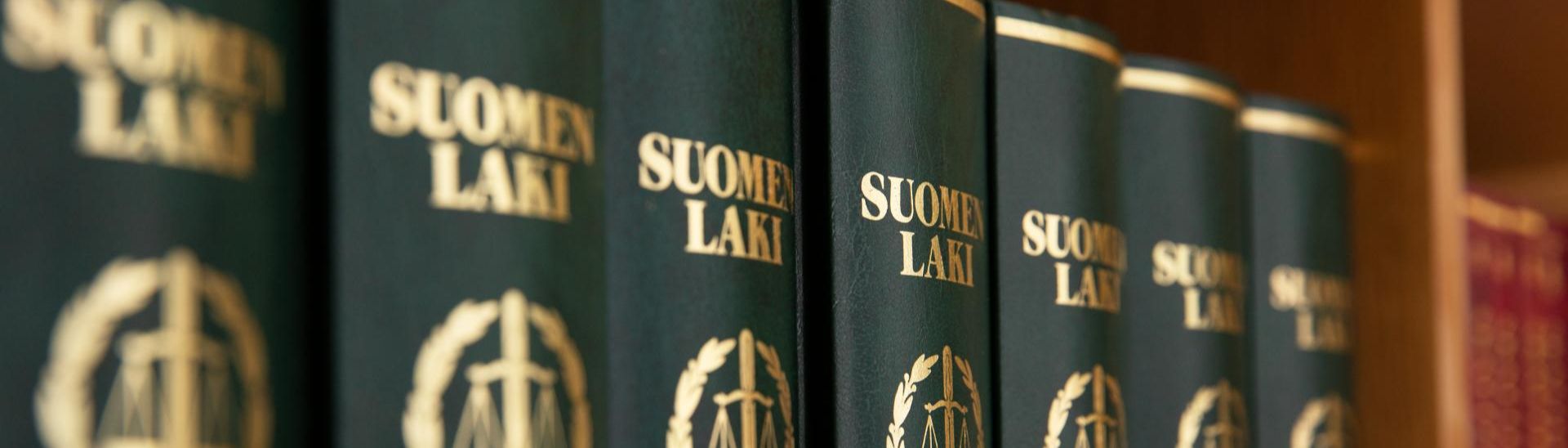 Suo­men laki -kir­joja kirjahyllyssä
